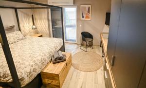Un pequeño dormitorio con una cama y una silla. en ELYSIUM Townhouse Imotski, en Imotski