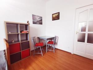 Una habitación con una mesa y dos sillas y una puerta. en CLA Group Apartment, en Sopron