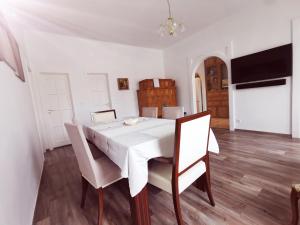 Un comedor con una mesa y sillas blancas. en CLA Group Apartment, en Sopron