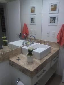 Apartamento Aconchegante para sua Viagem في ريو دي جانيرو: حمام مع حوض ومرآة كبيرة