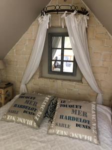 a bedroom with a bed with a window at Le clos de la Pommeraie maisonnette in Carly