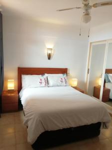 um quarto com uma grande cama branca e 2 candeeiros em Vero House TERRAZA DE LA PAZ em San Miguel de Abona