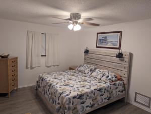 a bedroom with a bed and a ceiling fan at La Boca Beach House in Englewood