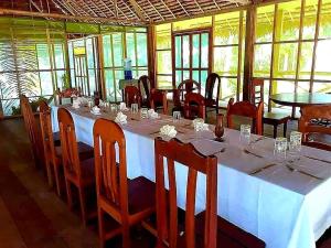 uma sala de jantar com uma mesa longa e cadeiras em Amazon Tropical Expeditions em Iquitos