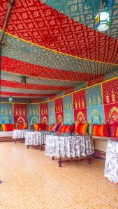 a room with rows of tables and a colorful ceiling at Riad Taghazoute in Marrakesh