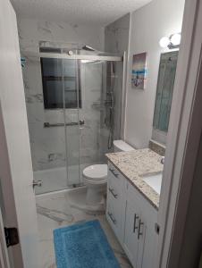 a bathroom with a shower and a toilet and a sink at La Boca Beach House in Englewood