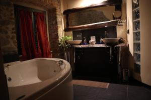 uma casa de banho com banheira e 2 lavatórios em Mansarda Pescia em Pescia