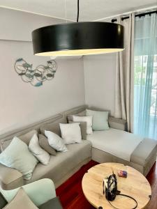 sala de estar con sofá y mesa en Brand new brilliant apartment at Athenian Riviera, en Atenas