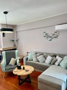een woonkamer met een bank en een tafel bij Brand new brilliant apartment at Athenian Riviera in Athene