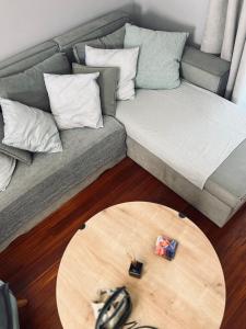 uma sala de estar com um sofá e uma mesa de madeira em Brand new brilliant apartment at Athenian Riviera em Atenas