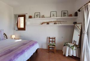 1 dormitorio con cama, silla y espejo en VILLA BELLA VISTA en Sant Francesc Xavier