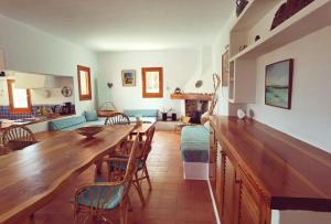 cocina y sala de estar con mesa de madera y sillas en VILLA BELLA VISTA en Sant Francesc Xavier