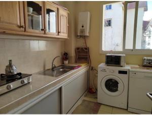 Il comprend une cuisine équipée d'un évier et d'un lave-linge. dans l'établissement Bel appartement à Ifrane, à Ifrane