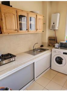uma cozinha com um lavatório e uma máquina de lavar roupa em Bel appartement à Ifrane em Ifrane