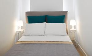 a bedroom with a bed with blue pillows and two lamps at Casa Ekaterina free wifii - spiaggia 200 metri in Brolo