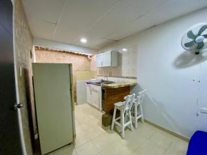 eine kleine Küche mit einer Theke und Stühlen darin in der Unterkunft Apartamento cerca del aeropuerto in Cartagena de Indias