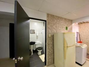 Apartamento cerca del aeropuerto في كارتاهينا دي اندياس: حمام مع ثلاجة ومرحاض