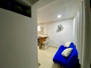 uma sala de estar com um sofá azul e uma cozinha em Apartamento cerca del aeropuerto em Cartagena das Índias