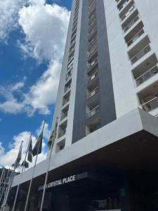 a tall building with flags in front of it at Flat 2313 - Crystal Place in Goiânia