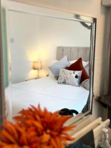 um reflexo de espelho de uma cama num quarto em Abbey House B & B em Penrith