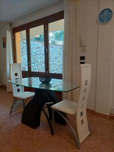 uma mesa de vidro com 2 cadeiras e uma janela de vidro em CASA ELGA em Borgo a Buggiano