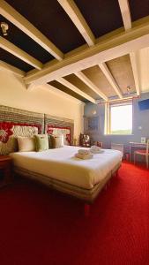 um quarto com uma cama grande e um tapete vermelho em Hôtel Bien-Être Aux Cyprès de Marquay em Marquay