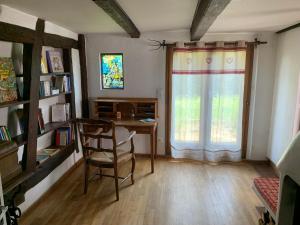 Ferme alsacienne في Soppe-le-Haut: غرفة مع مكتب ونافذة مع كرسي