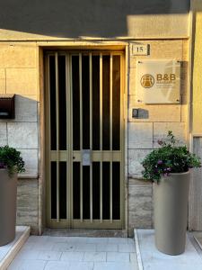 a door of a building with two potted plants in front at B&B Massafra nella Tebaide in Massafra