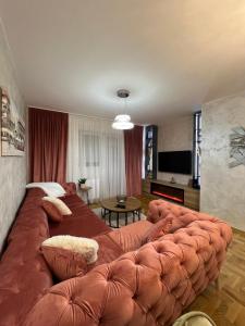 a large brown couch in a living room at Stan na dan,Beograd -Žarkovo in Bele Vode