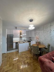 a kitchen and dining room with a table and a kitchen and a kitchen at Stan na dan,Beograd -Žarkovo in Bele Vode