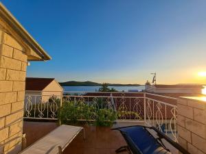 a balcony with a view of the water and a car at Apartments Ana Žaborić, 50 m od šljunčane plaže in Zaboric