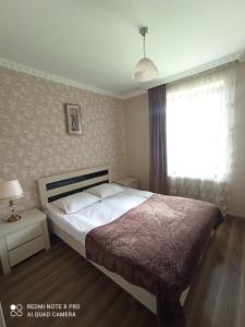 a bedroom with a bed and a window at Crystal Kazbegi in Stepantsminda