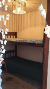 a room with a table with a bench and a chandelier at Aconchego Santiago's in Rio Formoso