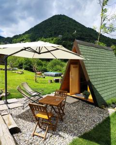 a table and chairs under a large umbrella at Baita Eleonora in Argegno