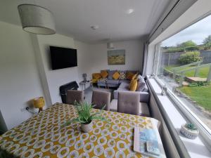 The Retreat, Cromer في كرومر: غرفة معيشة مع طاولة وأريكة