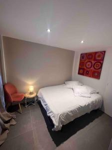 a small bedroom with a bed and a chair at Magnifique T3 duplex in Aubagne +3 photos