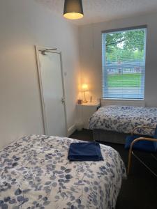 a hotel room with two beds and a window at Modern Manchester home, Free parking & near city centre in Manchester