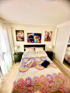 a bedroom with a large bed with a colorful comforter at Apartamento DESA Laguna Beach Vera Playa in Vera