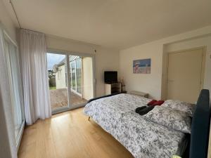 1 dormitorio con cama y ventana grande en Grande villa de 265m2 vue mer imprenable 11 à 12 personnes en Landéda