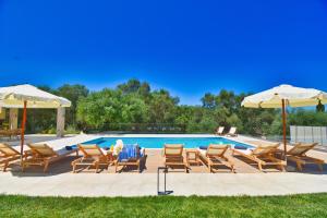 un gruppo di sedie e ombrelloni accanto alla piscina di Minerva Estate Corfu a Alepochórion
