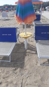 an umbrella and a table on the beach at Apartment Mare45 - 10 minutes walk from the beach - included parking, umbrella and sun-beds in Eraclea Mare