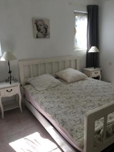 - une chambre avec un lit, 2 tables de chevet et une fenêtre dans l'établissement Villa paradis, à Fréjus