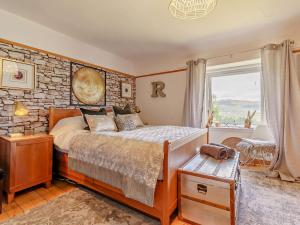皮特洛赫里的住宿－3 Bed in Pitlochry 59677，一间卧室设有一张床和石墙