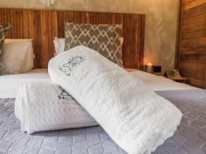 Una cama con dos toallas blancas encima. en Salvia Madre, en Santa Marta