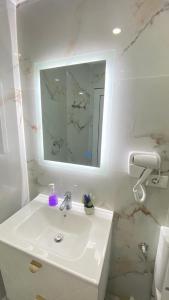 a white bathroom with a sink and a mirror at Guest house Luli Strumi in Berat