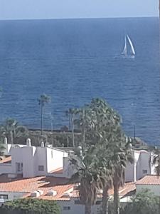 a sail boat in the ocean with palm trees at Vero House TERRAZA DE LA PAZ in San Miguel de Abona