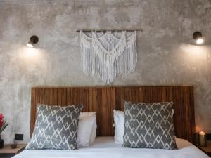 Una cama con dos almohadas y una cortina colgando encima. en Salvia Madre, en Santa Marta
