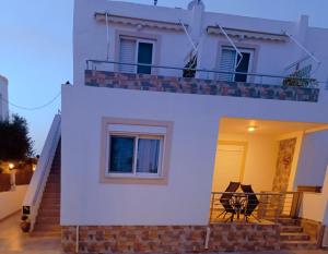 ein weißes Haus mit einem Balkon und einer Treppe in der Unterkunft G.S. Apartment in Mastichari