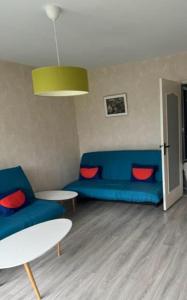 un soggiorno con un divano blu e un tavolo di ETS MPRS a Nantes