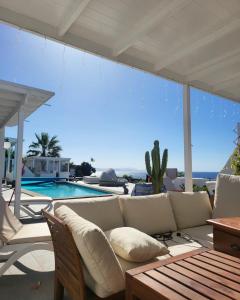 een woonkamer met een bank en een zwembad bij Villa Sunset Paradise with panoramic sea view, first line, sunsets in Playa Blanca